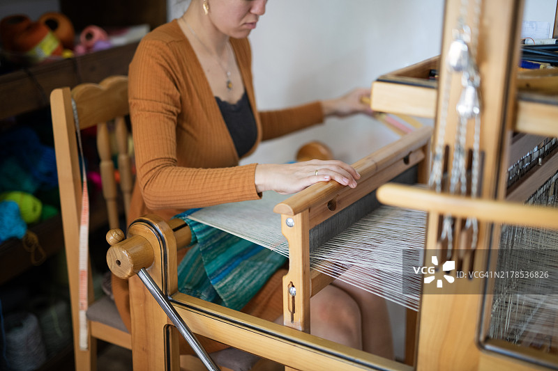 在工作室里编织精致传统地毯的女人图片素材