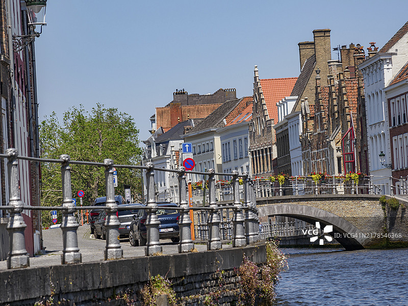 阳光明媚的比利时布鲁日运河街景：桥梁与历史建筑图片素材
