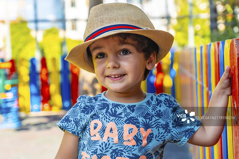 在操场上玩耍的戴帽子快乐男孩图片素材