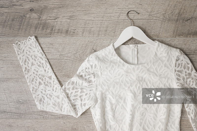 木纹背景上的白色蕾丝婚纱衣架图片素材