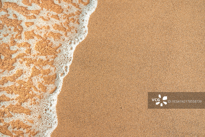 夏季海滩上的海浪泡沫和湿沙纹理图片素材