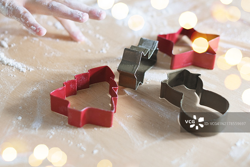圣诞食品背景，包含饼干、红色模具、面粉和双手图片素材