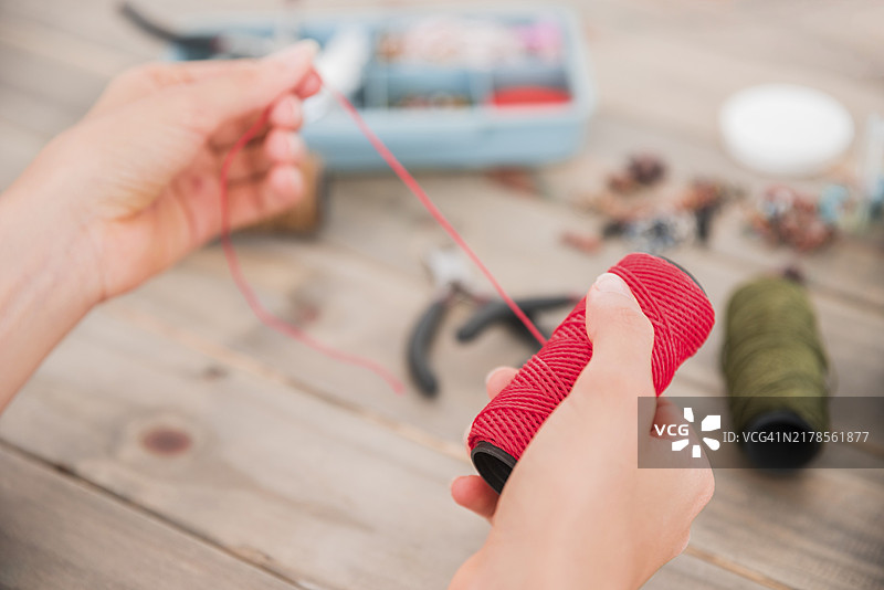 女人手持鲜红色毛线特写图片素材