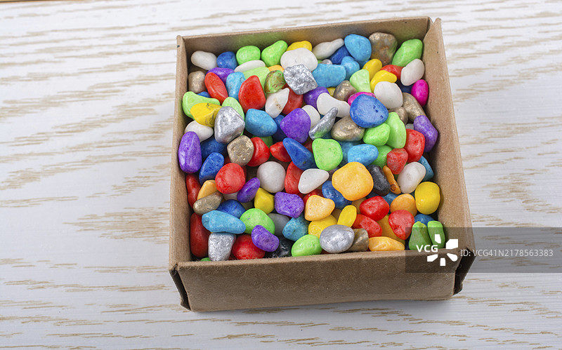 木纹盒子里的彩色小鹅卵石图片素材