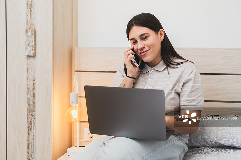 年轻女人在家使用笔记本电脑打电话工作图片素材