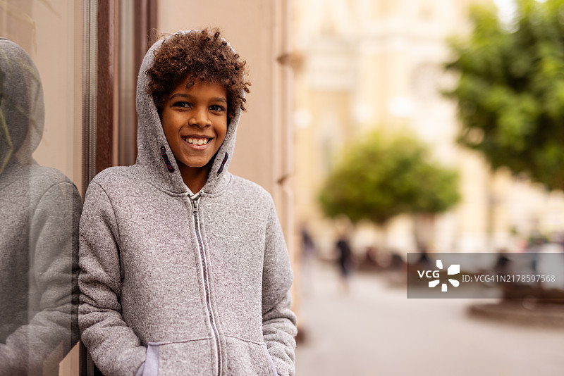 微笑看着镜头的戴帽衫非裔美国男孩图片素材