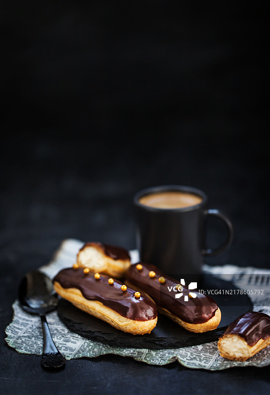 传统法式巧克力闪电泡芙，深色背景图片素材