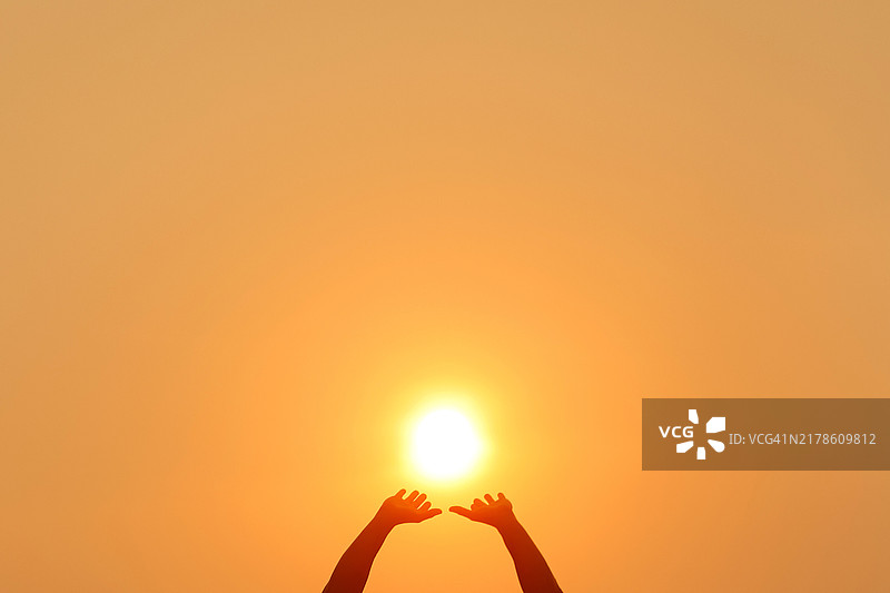 男人在日落时推动太阳图片素材