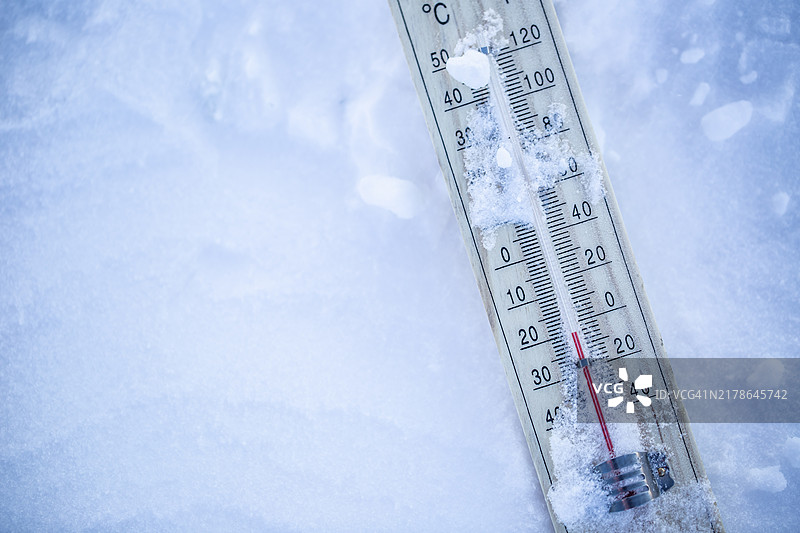 雪地上的温度计显示零度以下的低温，极端冬季冰冻天气图片素材