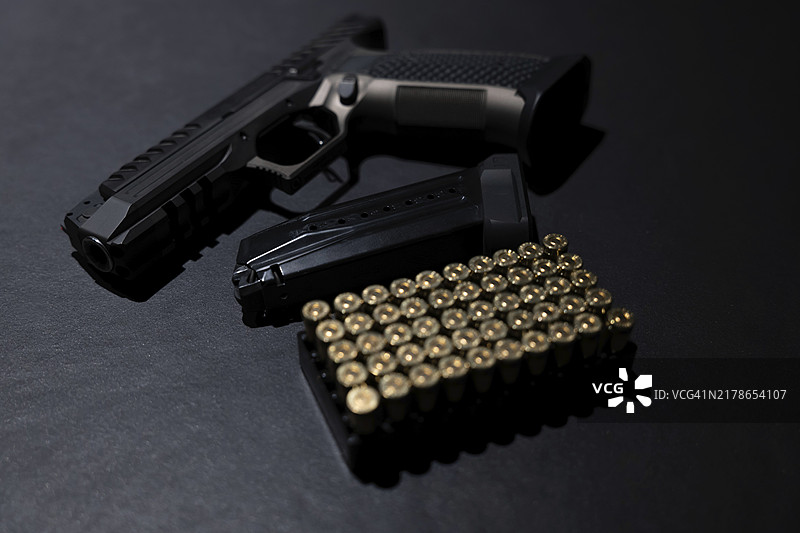 瑞士灰色背景上的现代优雅手枪和子弹图片素材