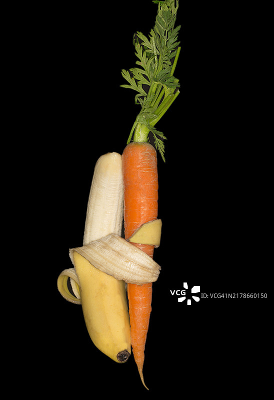 香蕉拥抱胡萝卜，象征爱与友谊的摄影，黑色背景图片素材
