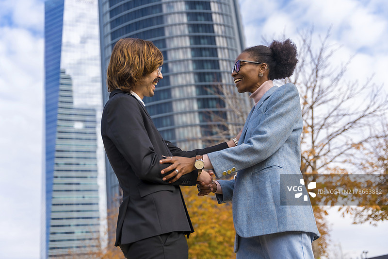 多民族的中年商人和女商人，问候同事，良好的工作环境图片素材