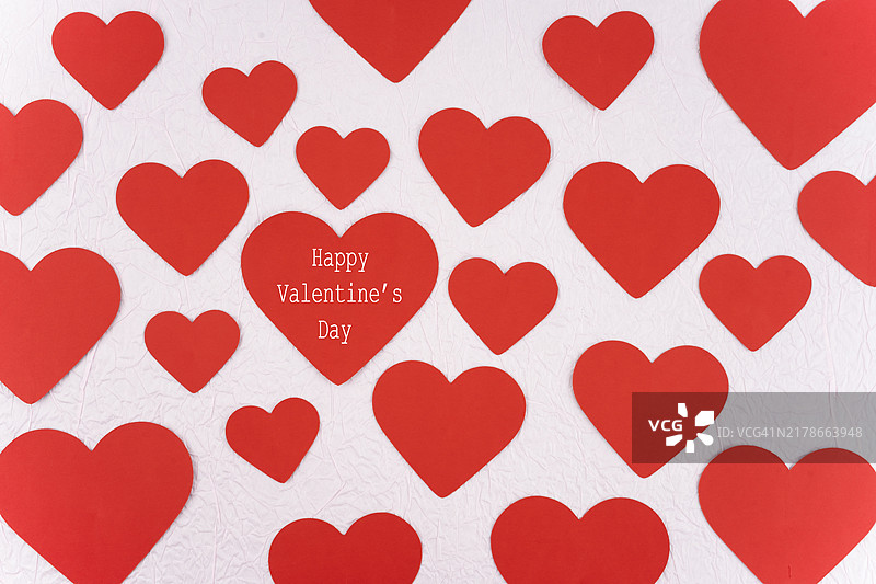 粉色背景上的红色纸心剪纸：情人节快乐图片素材