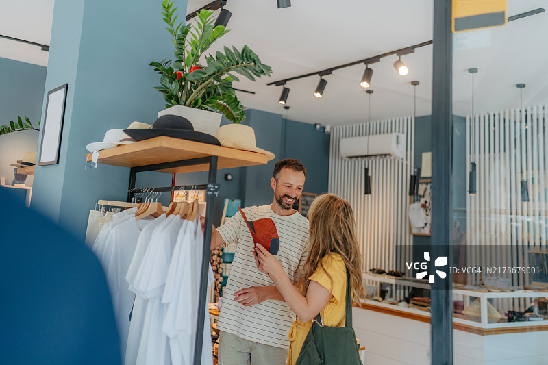 快乐情侣在纪念品店一起挑选T恤图片素材