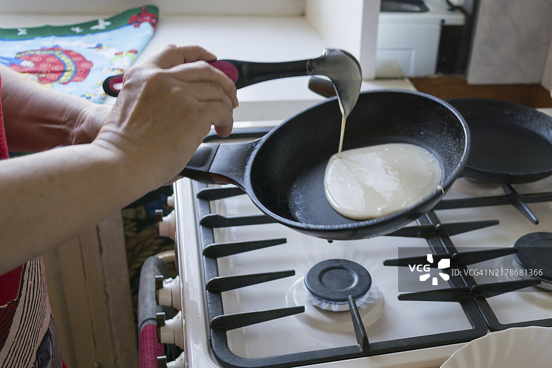 一位老妇人正在摊煎饼图片素材