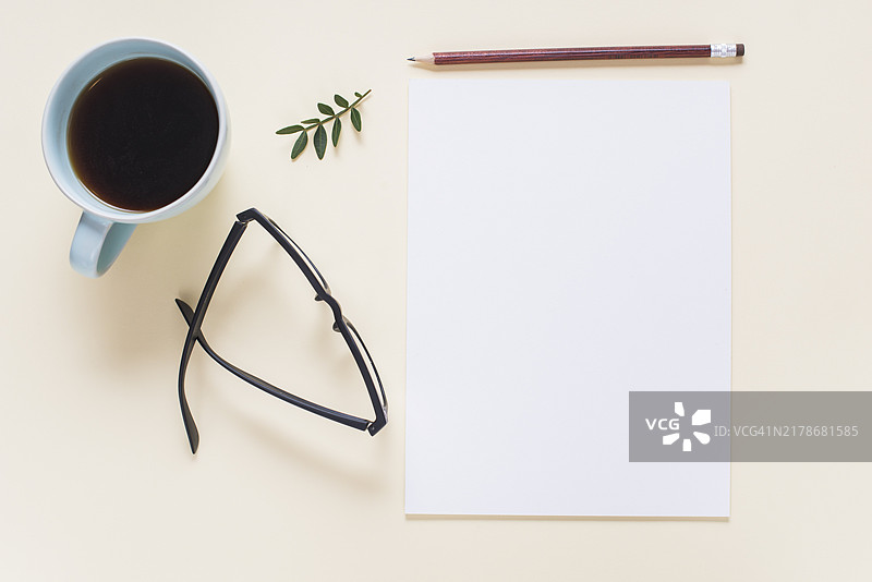 咖啡杯、眼镜、树枝、铅笔和空白页米色背景图片素材
