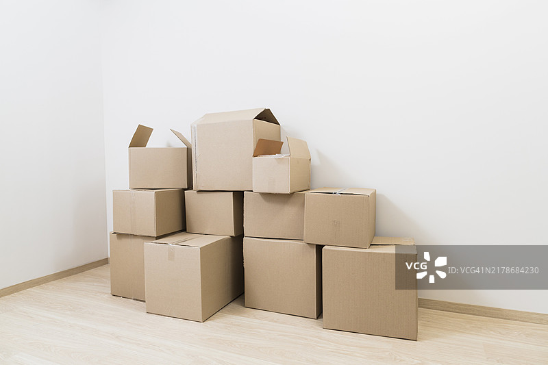 搬家纸箱堆放在新房间角落图片素材