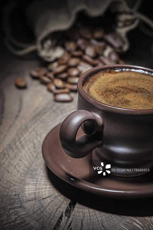 陶土咖啡杯中的浓缩咖啡和咖啡豆袋特写图片素材