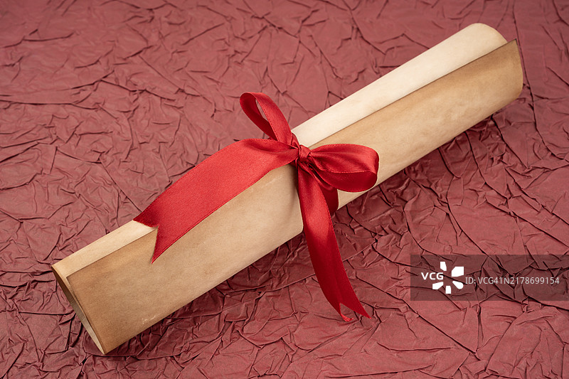 红色纸背景上的红色缎带旧纸卷轴，复古风格图片素材