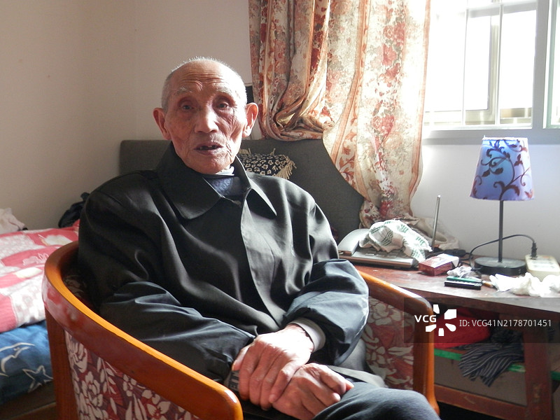 在家中的老年中国男性看着镜头图片素材