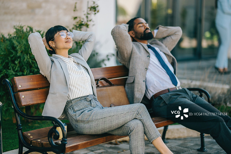 商务人士在办公楼前休息图片素材