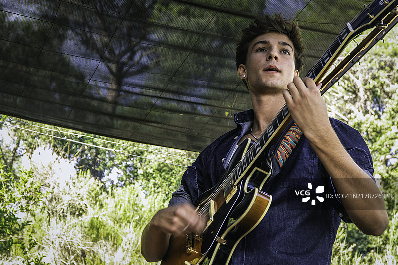 年轻吉他手户外彩排独奏图片素材