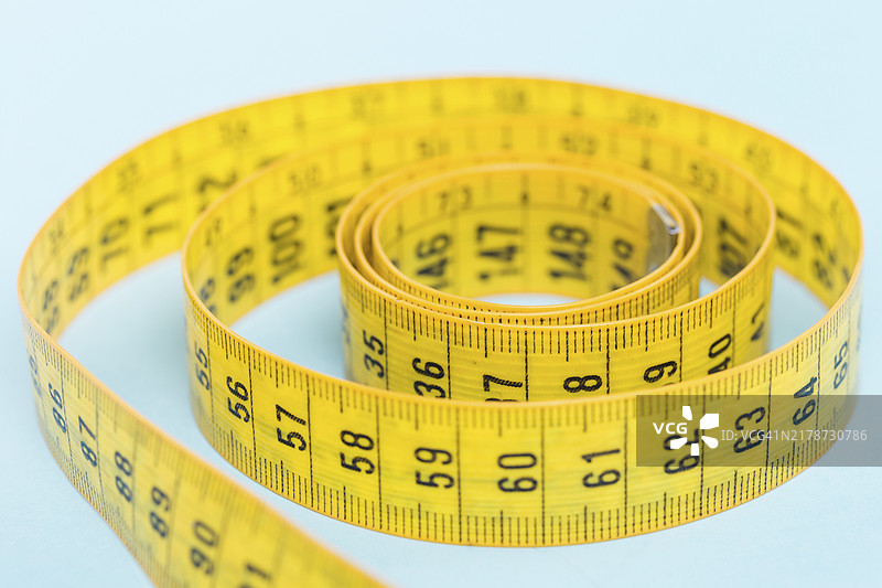 蓝色背景上的黄色卷尺图片素材