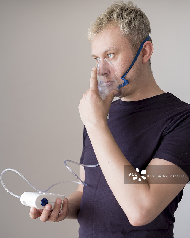 男人站立着使用氧气面罩图片素材
