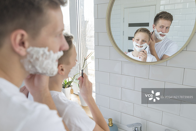 父子在浴室镜子前刮胡子图片素材