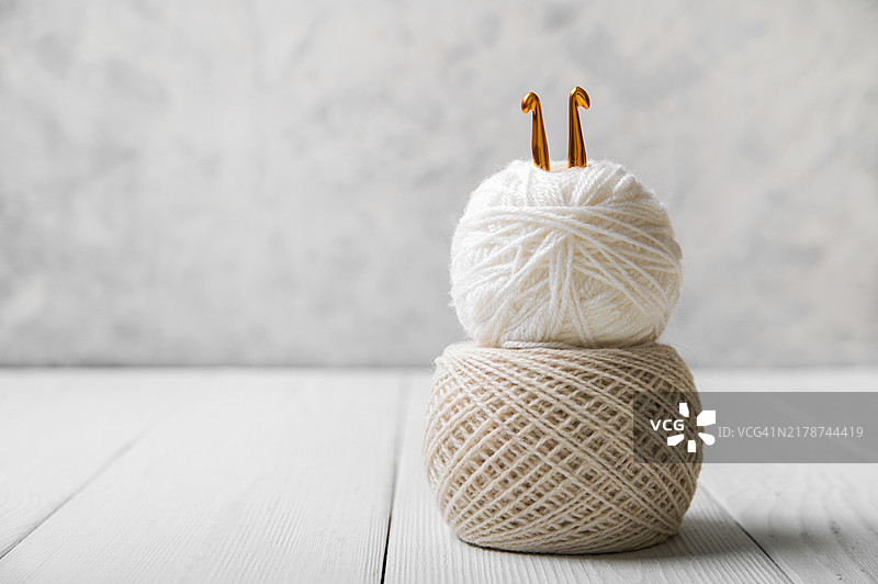 浅色背景上的中性彩色纱线球与针织钩针图片素材