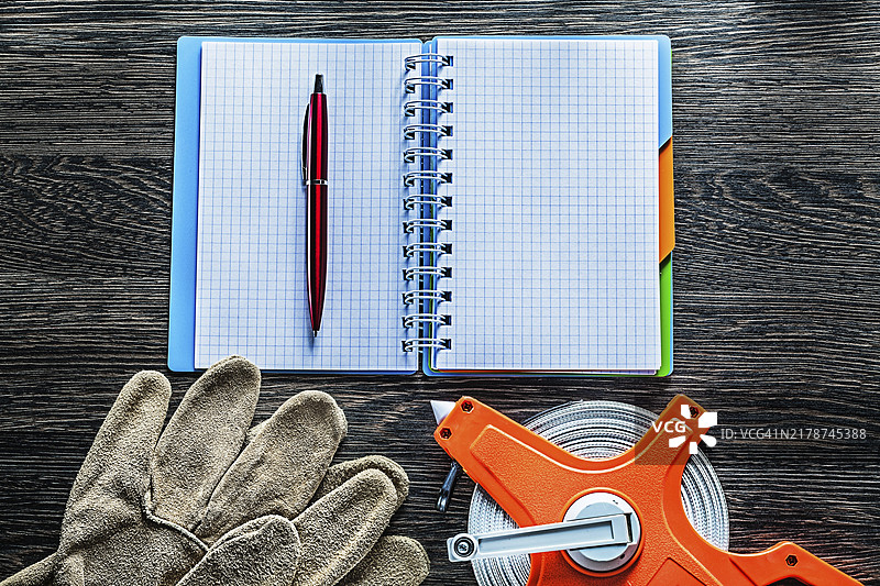 卷尺、防护手套、记事本、笔在木板上图片素材
