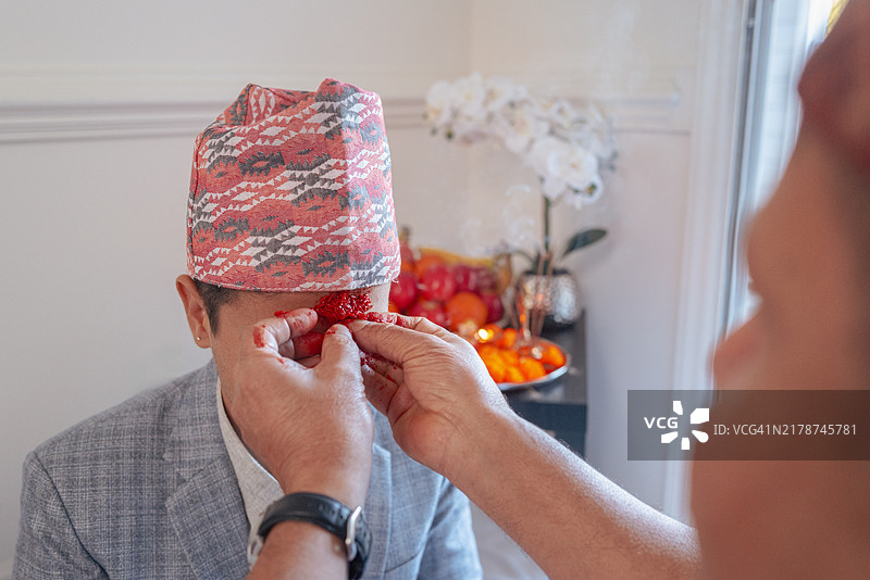 尼泊尔最重要的节日：快乐的达善节，长者为年轻人点提卡，达沙米节，达善节第10天，达卡托皮帽子，小儿子，特写图片素材