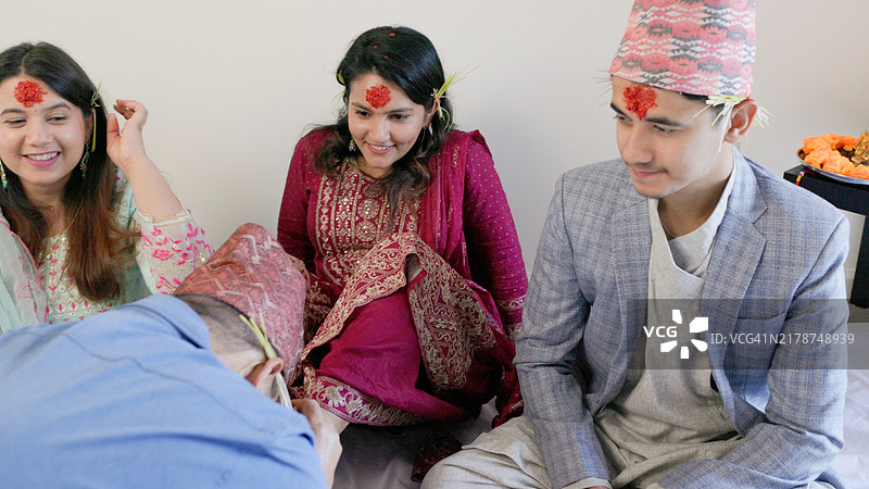 快乐的达善节 - 尼泊尔男子崇拜女孩作为女神的象征 - 尼泊尔最重要的节日 - 长者将女人的脚放在头上 - Dashami - 达善节的第10天 - 尼泊尔男子崇拜女孩作为女神的象征 - Maa Durza - 最小的女儿图片素材