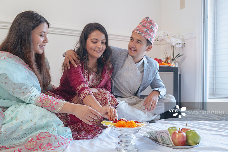 快乐的尼泊尔节日：制作Tiki的年轻尼泊尔人图片素材