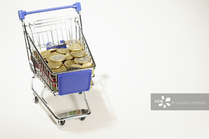 装满欧元硬币的购物车，白色背景图片素材