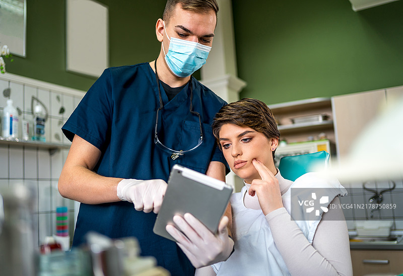 牙医在平板电脑上向患者展示X光片图片素材