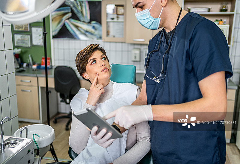 牙医在平板电脑上向患者展示X光片图片素材