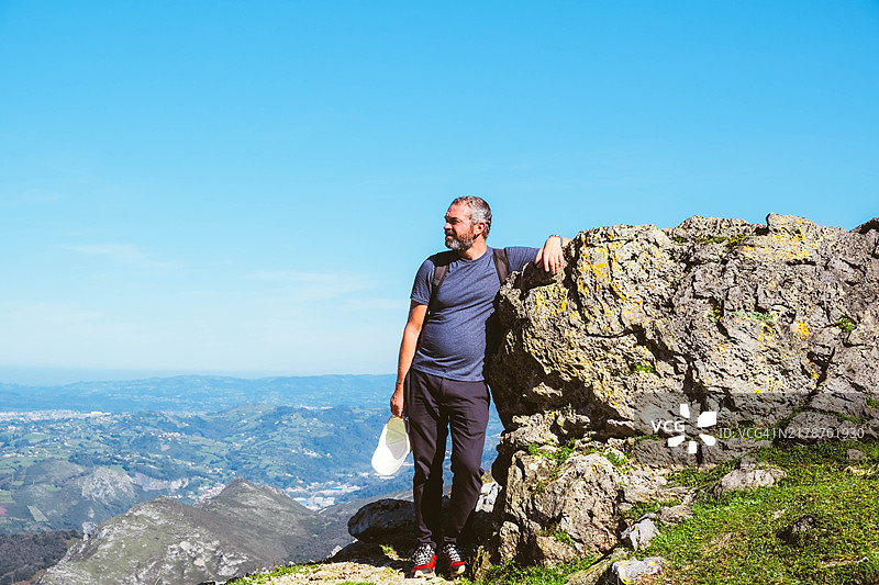 中年男性登山者在山顶摆姿势图片素材