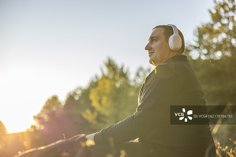体型偏胖的男人们站在有利位置，享受着放松的声音和美丽的地平线景色图片素材