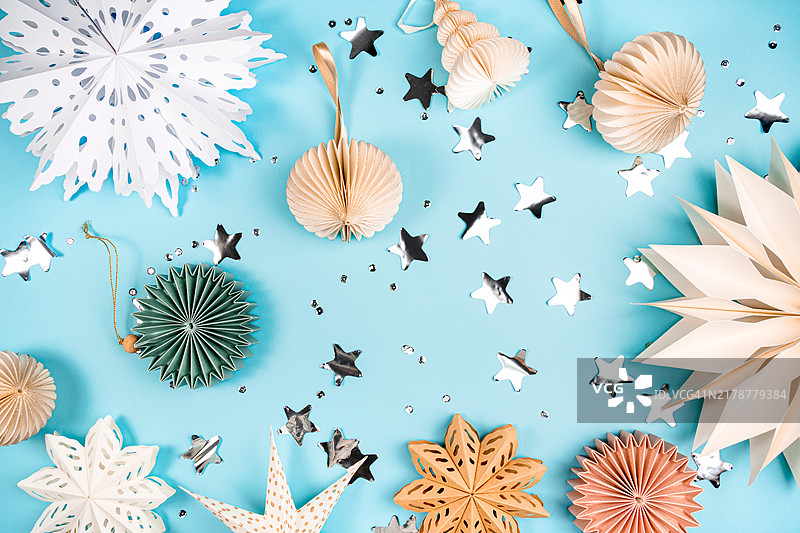 蓝色背景上的纸质雪花和圣诞树装饰品，圣诞新年图案图片素材