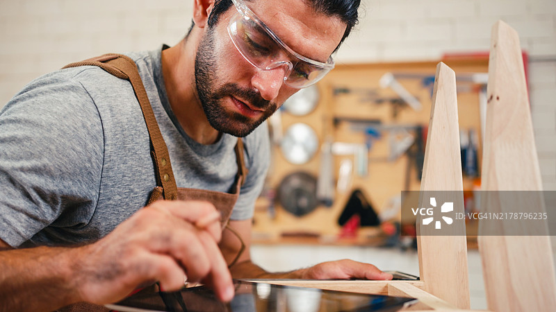 男性木家具工匠在DIY木工车间工作。图片素材