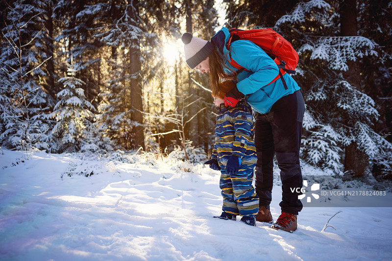 母亲和儿子在雪山上享受无忧无虑的冬日时光图片素材