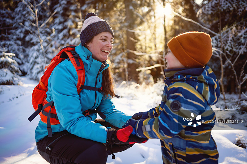 母亲和儿子在雪山上享受无忧无虑的冬日时光图片素材