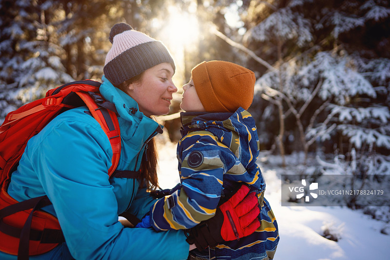 母亲和儿子在雪山上享受无忧无虑的冬日时光图片素材