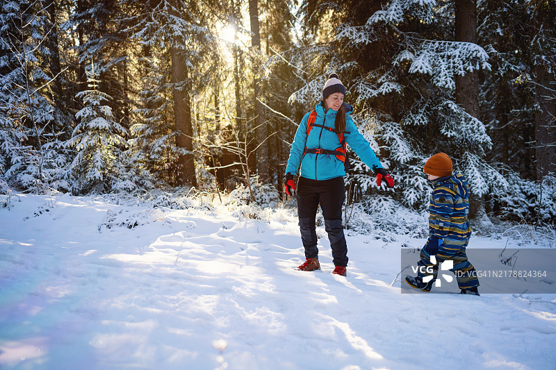 母亲和儿子在雪地中冬季远足图片素材