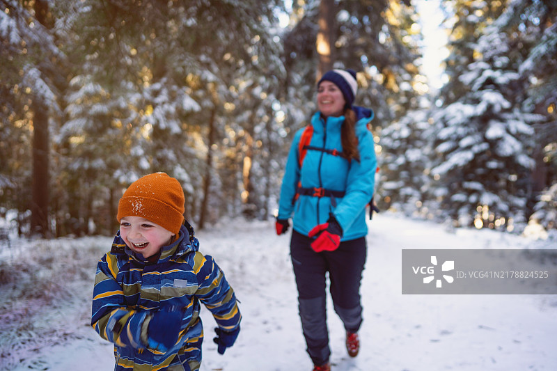 母亲和儿子在雪地中冬季远足图片素材