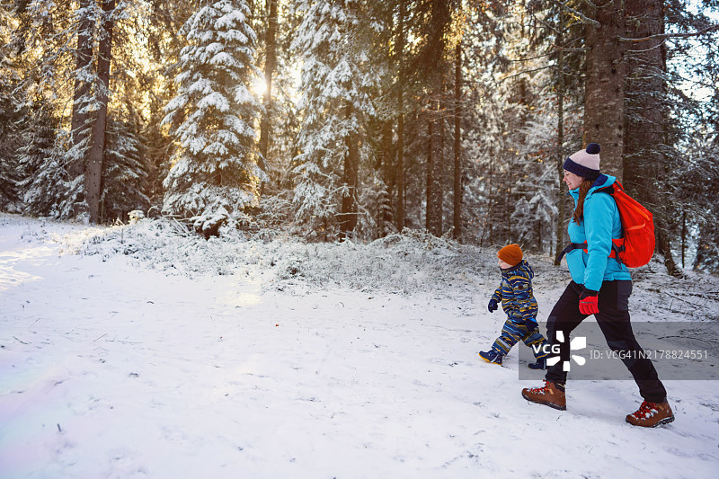 母亲和儿子在雪地中冬季徒步旅行图片素材