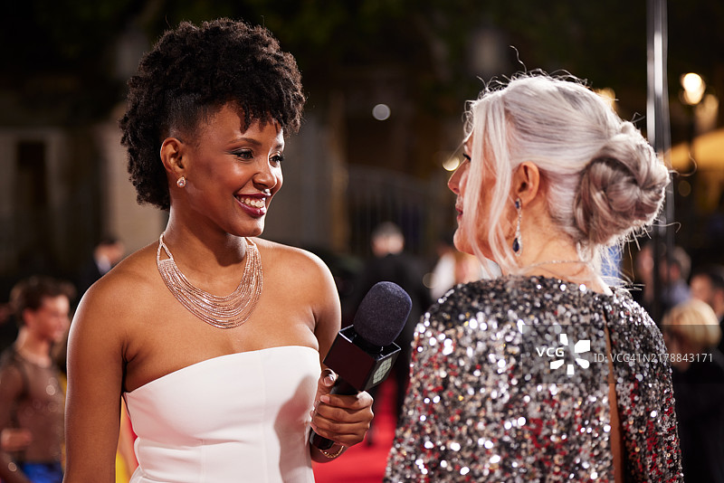 电影颁奖典礼前，记者在红毯上采访女演员图片素材