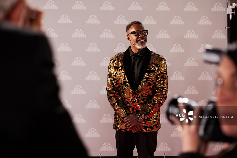 演员走在红毯上，为热切的记者摆姿势图片素材