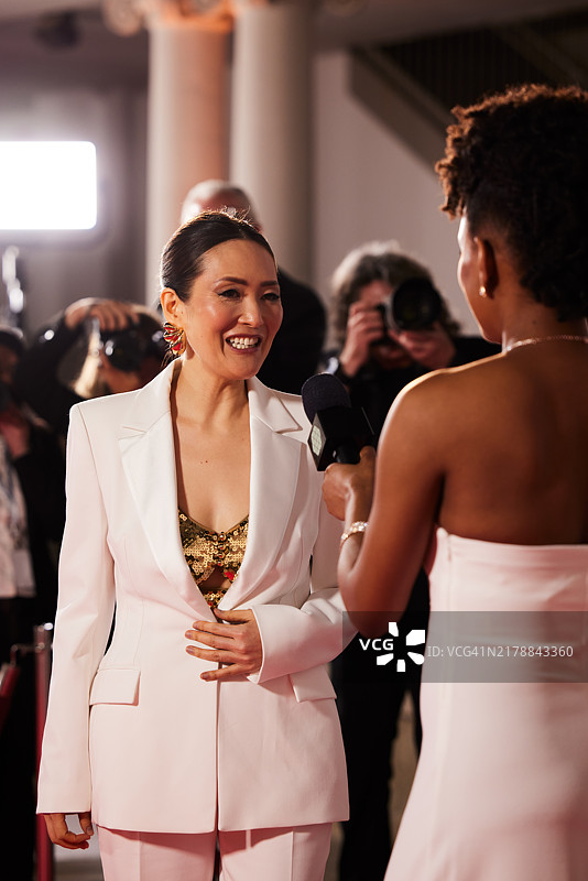 在红毯活动的现场直播中，新闻记者忙于采访女演员图片素材